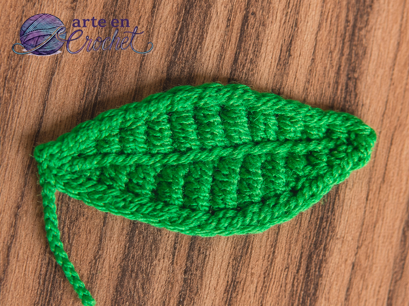 Hoja verde tejida a crochet para decorar un prendedor de café.